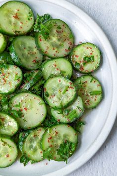 a white bowl filled with sliced cucumbers on top of a table