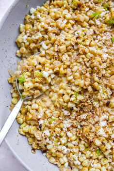 a white bowl filled with corn and broccoli covered in parmesan cheese