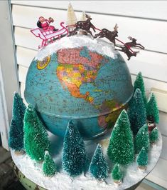 a globe with christmas trees and santa clause on top