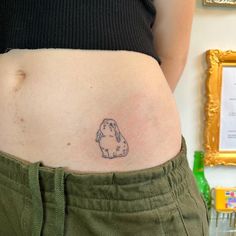 a woman's stomach with a tattoo of a dog on the lower part of her belly