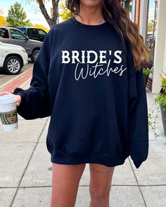 a woman wearing a bride's wishes sweatshirt and matching heels holding a coffee cup