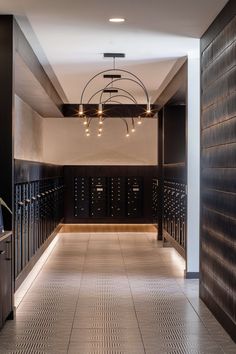 an empty hallway with many mailboxes and lights