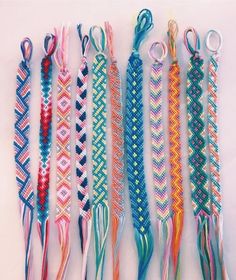 several different colored braids are lined up on a white surface with scissors in the middle