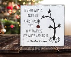 a wooden sign that says it's not what under the christmas tree that matters its who's around it