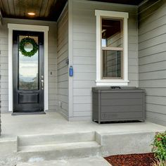 the front door of a house with an air conditioner on the steps and wreath