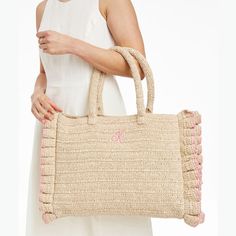 This beach-ready oversized tote, crafted from unlined twisted raffia, is a must-have on sunny days. The durable, structured handle, tassel accessory and playful handcrafted ruffled edging make it stand out, at the shore, by the pool or anywhere you need ample storage for long summer days. A monogram adds a personal touch.    17"w x 4"d x 13"h  Handle drop: 8"  Paper straw and twisted raffia.  Spot clean and store only when completely dry.  Made in India.  Monogramming is embroidered. Chic Beach Bag With Rolled Handles For Spring, Spring Beach Bag With Fringe, Chic Straw Bag With Fringe, Chic Straw Beach Bag With Tassels, Chic Beach Straw Bag With Tassels, Chic Tassel Straw Beach Bag, Chic Fringed Beach Bag For Vacation, Natural Color Beach Bag With Tassels For Spring, Spring Straw Beach Bag With Rolled Handles