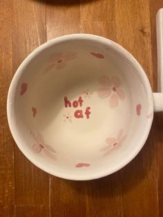 a bowl with the word hot at written in red on it next to a spoon