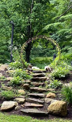 a stone path in the middle of a lush green forest