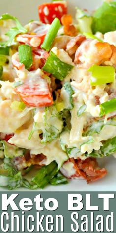 a white plate topped with chicken salad next to lettuce and tomatoes