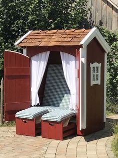 a red and white shed sitting on top of a brick walkway