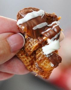 a hand holding a waffle with chocolate and marshmallow toppings on it