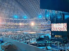 a large crowd is sitting in the middle of an arena at a concert or convention