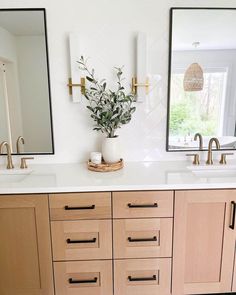 a bathroom with double sinks and two mirrors on the wall next to eachother