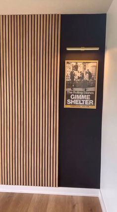 an empty room with wooden slats on the wall and a poster on the door