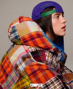 a woman wearing a plaid jacket with a purple beanie on top of her head