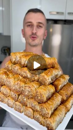 a man holding a tray full of pastries in front of him and making a funny face