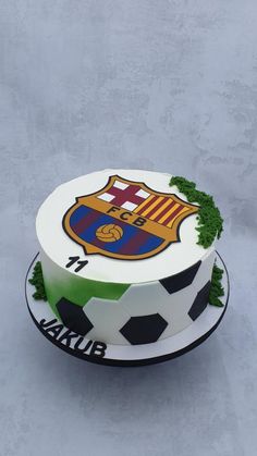 a cake decorated with soccer balls and the crest of barcelona