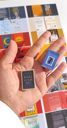 a person holding up a small square brochure in front of a colorful background