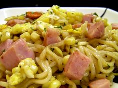 a white plate topped with pasta and ham