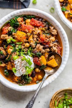 two white bowls filled with soup on top of a table