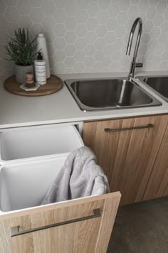 a kitchen sink with an open drawer in the middle and a dishwasher next to it