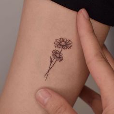 a woman's arm with a flower tattoo on the left side of her body