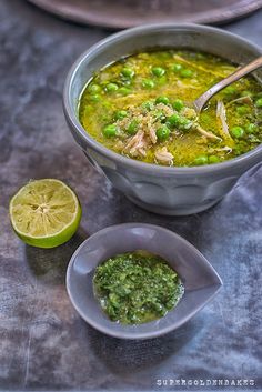 a bowl of soup with peas and limes