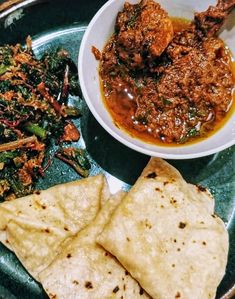 a green plate topped with meat and veggies next to a bowl of soup