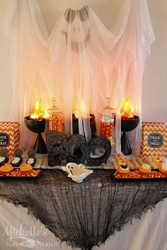 a table topped with halloween treats and candles