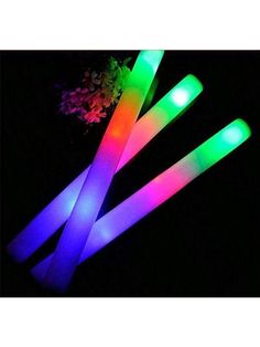 three glow sticks are shown in the dark