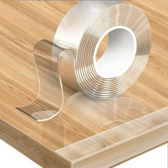 a roll of clear tape sitting on top of a wooden table