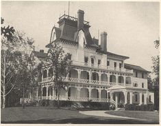 an old black and white photo of a large house with balconies on it