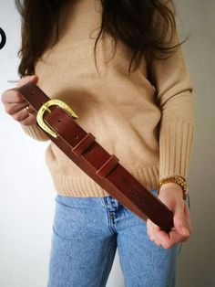 This personalized genuine leather belt with a horseshoe buckle is a unique and thoughtful gift for any equestrian. Handcrafted of premium quality vegetable-tanned Italian leather, our belt is designed to be a stylish accessory that lasts for years. The solid brass buckle features an intricate horseshoe design, adding a touch of equestrian flair to this leather belt. With the option to be engraved with a name or monogram, our personalized equestrian belt is a one-of-a-kind gift for horse lovers..The belt is available in various sizes to ensure a comfortable and secure fit, and the leather will soften and patina over time for a classic and timeless look. The solid brass buckle is in the shape of a horseshoe, which is a symbol of good luck and fortune, making it an ideal gift for someone who Equestrian Belt, Equestrian Belts, Horseshoe Design, Horse Lovers, Gifts For Horse Lovers, Genuine Leather Belt, Suspender Belt, Brass Buckle, Personalized Leather