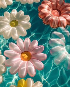 an array of flowers floating on top of a body of water with ripples around them