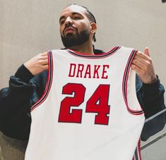 a man holding up a jersey with the number 24 on it