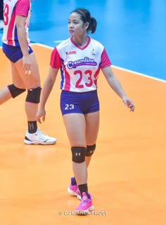 two women are playing volleyball on an indoor court