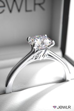 a diamond ring sitting on top of a white box