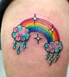 a woman's stomach with a rainbow and clouds tattoo on it