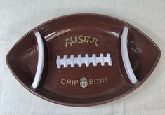 a brown football shaped ashtray with the words austar on it