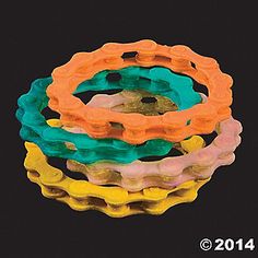 four different colored plastic rings sitting on top of each other in front of a black background