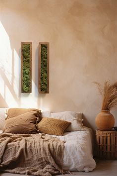 a bed sitting next to a window with two vases on top of the bedspread