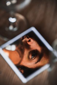 the reflection of a man's face in a mirror on top of a table