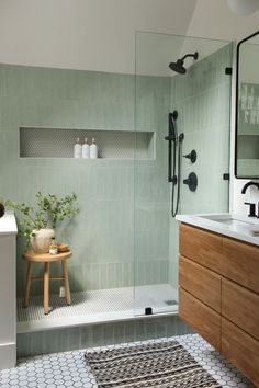 a bathroom with green tile and wooden cabinets