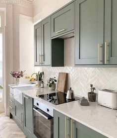 an image of a kitchen setting with green cabinets and marble counter tops on instagram