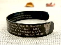 The Custom Engraved Memorial Military Bracelet is a solemn tribute and a heartfelt way to remember the fallen heroes and loved ones we've lost. Crafted from durable military black stainless steel, this KIA Bracelet serves as both a symbol of honor and a cherished keepsake. With its customizable engraving, it allows you to etch the name, rank, and date of passing of your fallen hero, ensuring a personal touch in honoring their memory.  PRODUCT FEATURES: * Material: Black stainless steel cuff * Du Military Bracelet, Remember The Fallen, Personalized Leather Bracelet, Memorial Bracelet, Black Army, Fallen Heroes, Stainless Steel Plate, Steel Plate, Black Stainless Steel