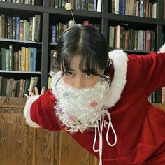 a woman dressed as santa claus in front of bookshelves