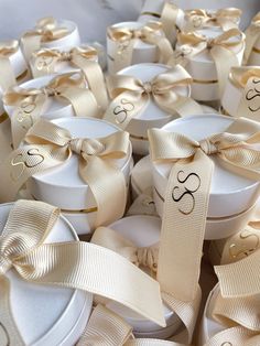 many white boxes with gold ribbons tied around them and numbers on the top, one for each