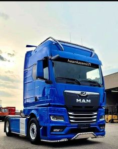 a blue semi truck parked in front of a building