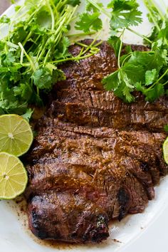 steak with cilantro and lime garnish on a white plate, ready to be eaten