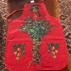 a red apron with flowers on it sitting on a table